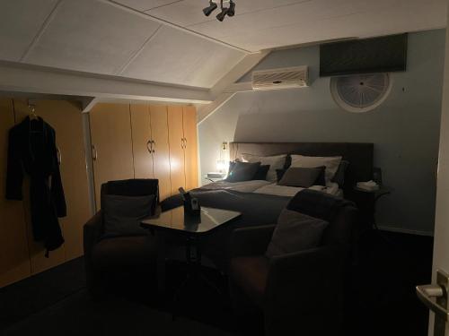 a bedroom with a bed and a couch and a table at La Nuova Casa del Campo (vh De Kamp) in Dinxperlo