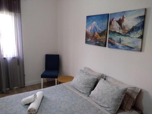 a bedroom with a bed and a blue chair at Alojamento Almirante in Viseu