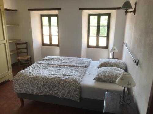 une chambre avec deux lits et deux fenêtres dans l'établissement maison-michael, à Bédoin