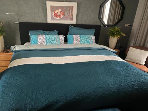 a large bed with blue and white sheets and pillows at La Nuova Casa del Campo (vh De Kamp) in Dinxperlo