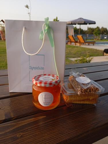 two jars of honey and a bag on a bench at Olympia Suites in Pýrgos
