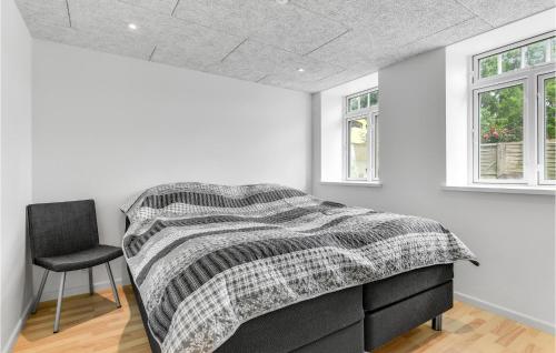 a bedroom with a bed and a chair in it at Pet Friendly Home In Højer With Kitchen in Højer