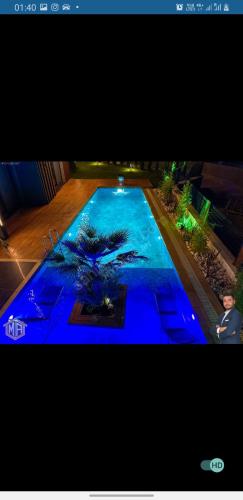 un homme debout devant une grande piscine dans l'établissement kiralik ultra lux villa, à Kusadası