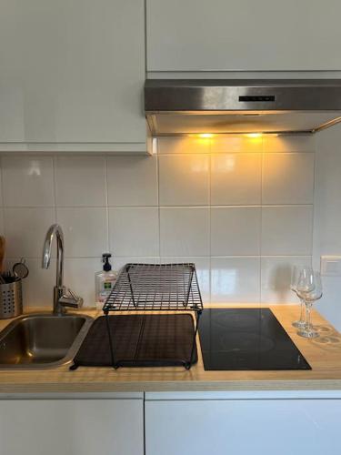- un comptoir de cuisine avec évier et porte-vaisselle dans l'établissement Votre pied-à-terre en plein Paris, à Paris