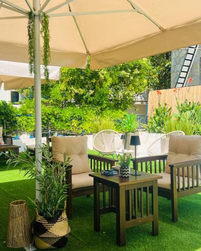 a group of chairs and tables under an umbrella at Cinque Stelle Apartments in Glífa