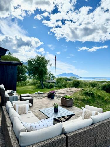 a patio with a couch and a table on a deck at Amazing seaview - Lodge in Bodø
