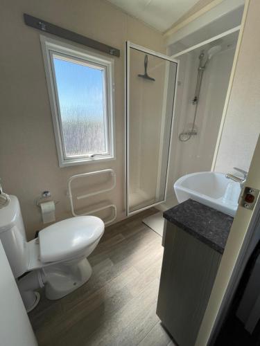 une salle de bain avec toilettes, lavabo et fenêtre dans l'établissement le coup de coeur, à Berck-sur-Mer