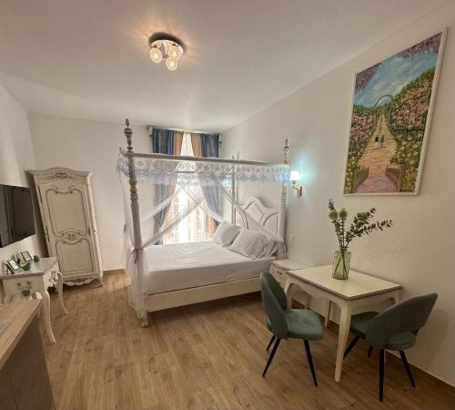 une chambre avec un lit et une table avec des chaises dans l'établissement Studio à Baldaquin du Cloitre, à Narbonne