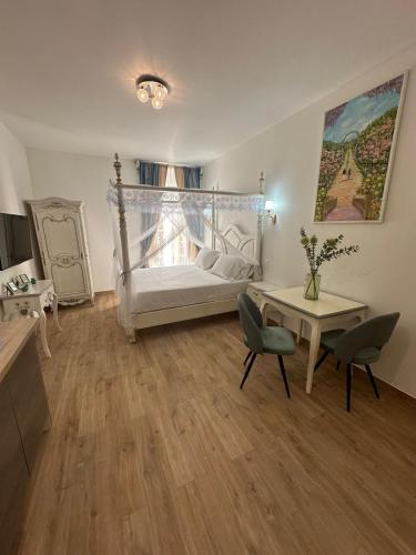 une chambre avec un lit, une table et des chaises dans l'établissement Studio à Baldaquin du Cloitre, à Narbonne