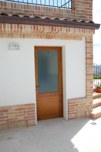 a brick building with a wooden door at Villa Liliana, Exclusive Property in Monte Rinaldo