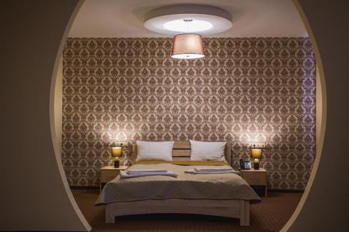 a bedroom with a bed and a wall with a mirror at Mіnі Gotel Pozitiv in Horodets'ke