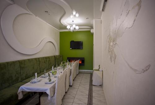a row of tables in a room with green walls at Mіnі Gotel Pozitiv in Horodets'ke