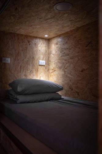 una cama en una habitación con una pared de madera en 耶舍 YES SIR 旅宿, en Isla Verde