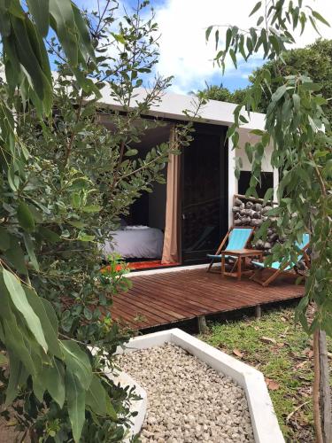 a room with a bed on a wooden deck at CosyBe Villas in Praia do Tofo