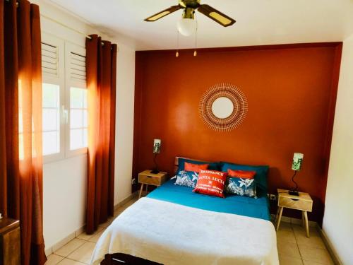 a bedroom with a bed and a ceiling fan at Appartement Coco Antilles ,vue mer, terrasse couverte 25m2,plage à pied in Sainte-Luce