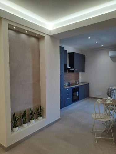 a kitchen with blue cabinets and a table with plants at maraneri rooms in Bovalino Marina