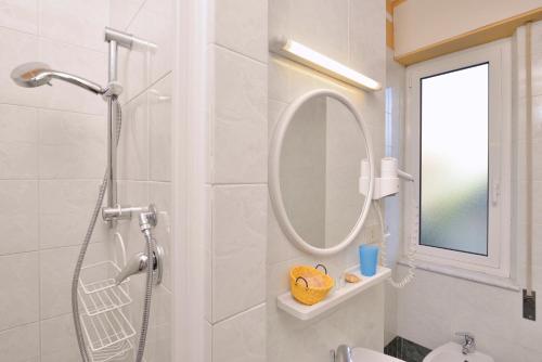 a white bathroom with a shower and a mirror at Antica Locanda Luigina in Mattarana