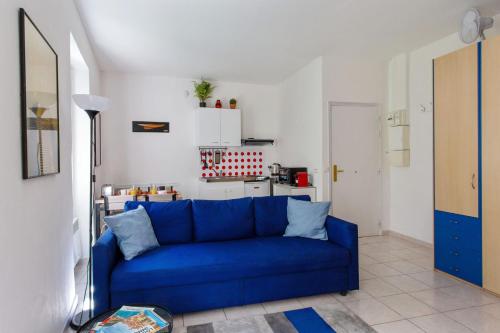- un canapé bleu dans une chambre avec cuisine dans l'établissement Appartement Gambetta - Welkeys, à Nice