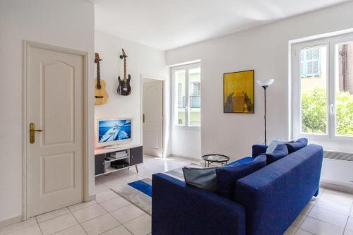 un salon avec un canapé bleu et une télévision dans l'établissement Appartement Gambetta - Welkeys, à Nice