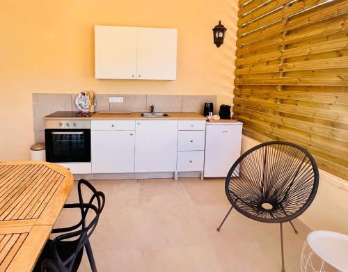 a kitchen with white cabinets and a table and chairs at Casa de Los Lirios in Muro de Alcoy