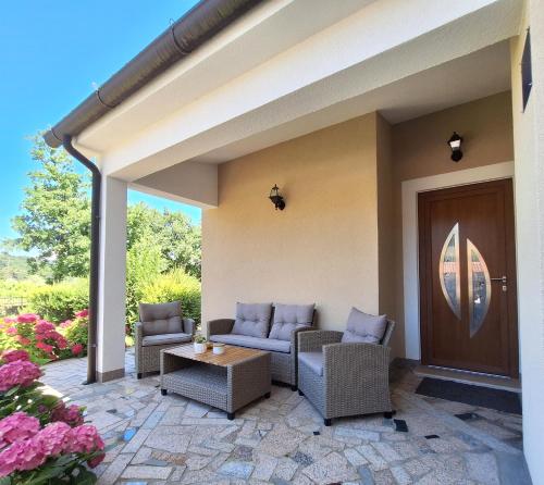 a patio with couches and a table and flowers at Apartment Mita in Grožnjan