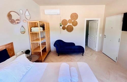 a bedroom with a bed and a blue chair at Casa de Los Lirios in Muro de Alcoy