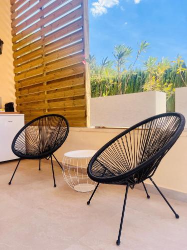 two black chairs sitting in front of a window at Casa de Los Lirios in Muro de Alcoy