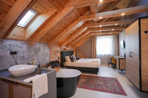 a bathroom with a tub and a bedroom with a bed at ChaChaCha House Vendégház in Egerszalók