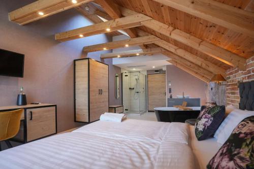 a bedroom with a large white bed and a bathroom at ChaChaCha House Vendégház in Egerszalók
