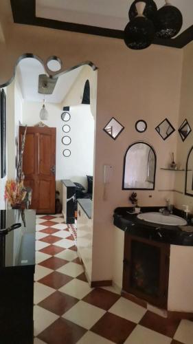 a bathroom with a sink and a checkered floor at شقة للكراء اليومي للعائلات فقط وسط مدينة الجديدة تبعد 10 دقائق عن البحر in El Jadida
