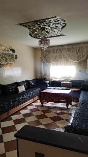 a living room with a couch and a checkered floor at شقة للكراء اليومي للعائلات فقط وسط مدينة الجديدة تبعد 10 دقائق عن البحر in El Jadida