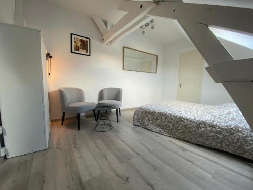 une chambre avec un lit, une table et des chaises dans l'établissement Chez Clovis - proche gare centre et arena, à Reims