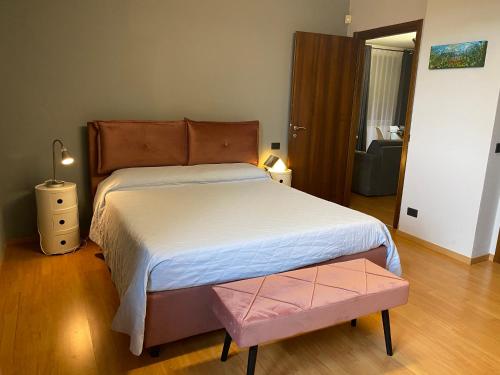 Un dormitorio con una cama grande con cabecero de madera. en Agriturismo bottega di Rosanna, en Castagnole Lanze