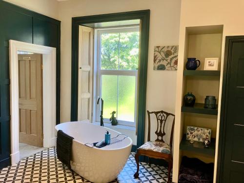 a bath tub in a room with a window at Above & Beyond at Warriston Lodge in Moffat
