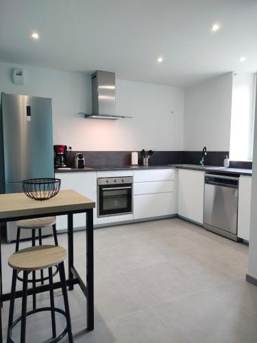 une cuisine avec une table et des chaises dans l'établissement Gîte atypique de Maubourg, de une à 8 personnes, proche départ passerelle, à Saint-Maurice-de-Lignon