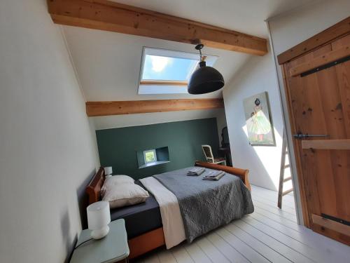 a bedroom with a bed with a green accent wall at Gîte La Boutardière in Saint-Aubin-le-Cloud