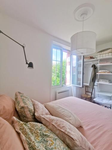 une chambre avec un lit et une fenêtre dans l'établissement Au Coin Fleuri, à La Bernerie-en-Retz