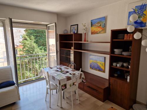 une salle à manger avec une table et un balcon dans l'établissement Villa Rimbaud, à Cannes
