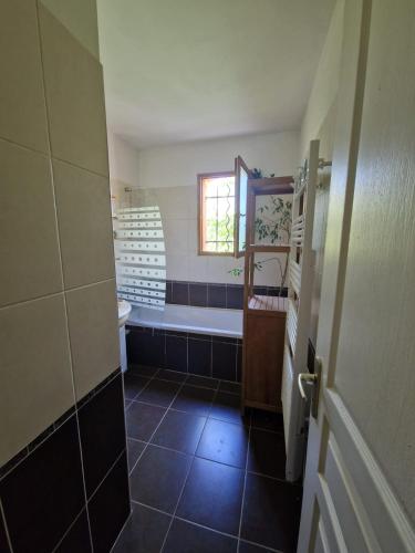 une salle de bain avec une baignoire, des toilettes et un lavabo dans l'établissement Villa arborée avec grande piscine, à Campagnan