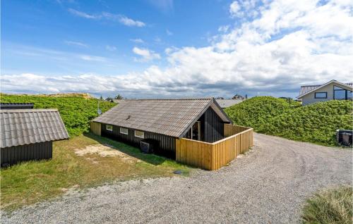 a small house with a roof on a gravel road at Lærkereden in Vejers Strand