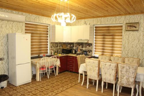 a kitchen with a white refrigerator and a table with chairs at Familihome in Ganja