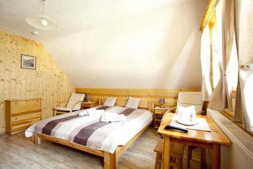 a bedroom with a bed and two chairs at Penzión Koliba in Dolný Kubín