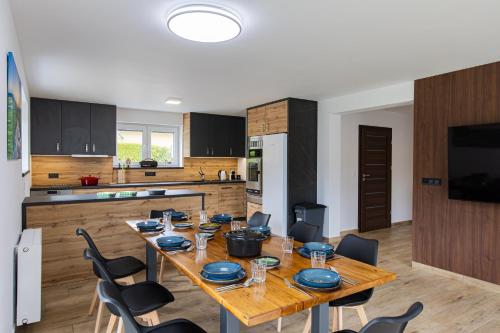 a kitchen with a wooden table and chairs in a room at Wellness Chalupa Hayek in Česká Ves