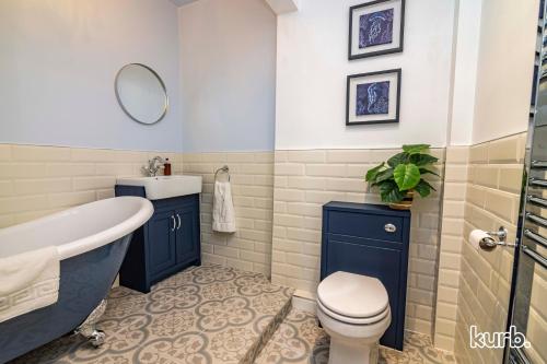 a bathroom with a tub and a toilet and a sink at Fern Cottage - 5 bedroom House free Parking in Nottingham
