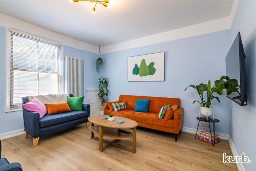 a living room with two couches and a table at Fern Cottage - 5 bedroom House free Parking in Nottingham