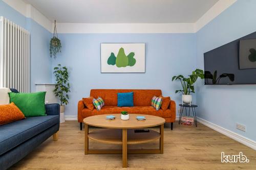 a living room with a couch and a table at Fern Cottage - 5 bedroom House free Parking in Nottingham