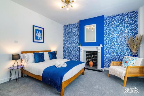 a bedroom with blue walls and a bed and a fireplace at Fern Cottage - 5 bedroom House free Parking in Nottingham