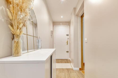 La salle de bains est pourvue d'un miroir et d'un vase de fleurs. dans l'établissement St Maurice-Appartement familial Bois de Vincennes Paris, à Saint-Maurice