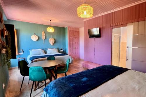 a hotel room with a bed and a table and chairs at Casa de Los Lirios in Muro de Alcoy