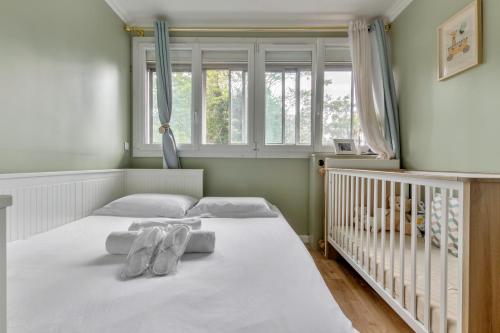 une chambre avec un lit avec deux serviettes dessus dans l'établissement St Maurice-Appartement familial Bois de Vincennes Paris, à Saint-Maurice